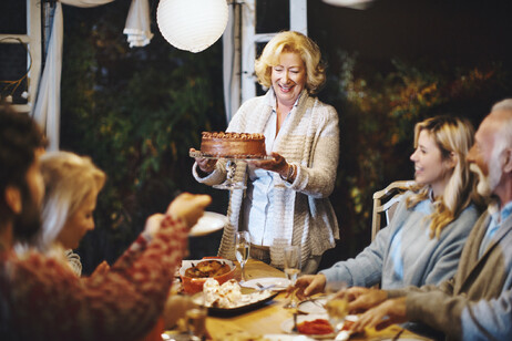 Pranzo della domenica , a tavola in famiglia, torta in primo piano. foto iStock.