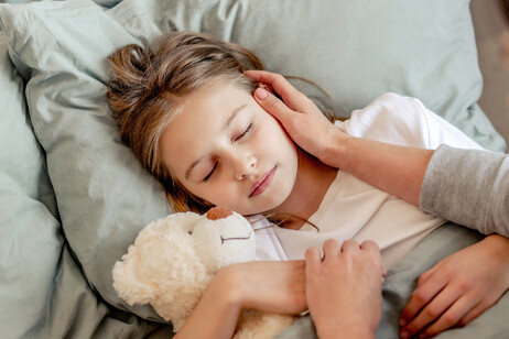 Una bambina dorme abbracciata all'orsacchiotto foto iStock.