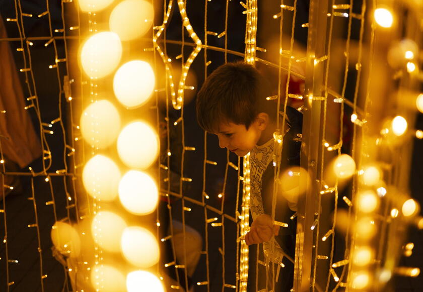 Un bambino gioca tra le luminarie di Natale a Johannesburg, in Sud Africa