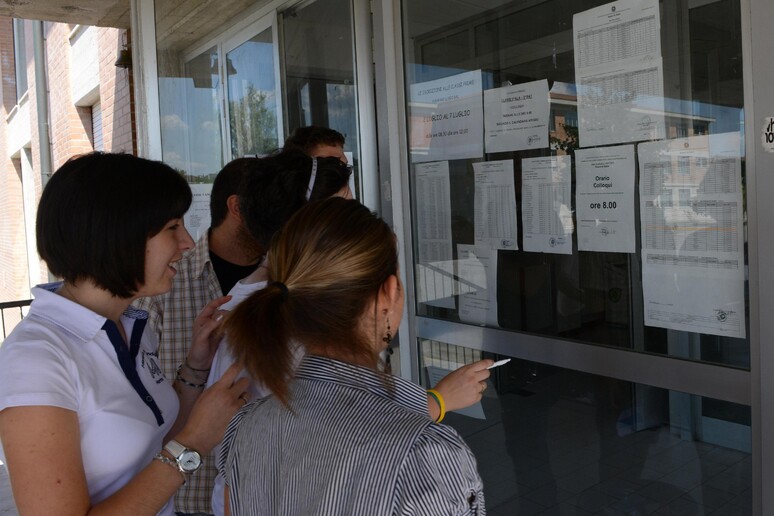 Studenti guardano i quadri con i voti della maturità - RIPRODUZIONE RISERVATA