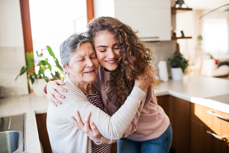 Una adolescente abbraccia la nonna foto iStock. - RIPRODUZIONE RISERVATA