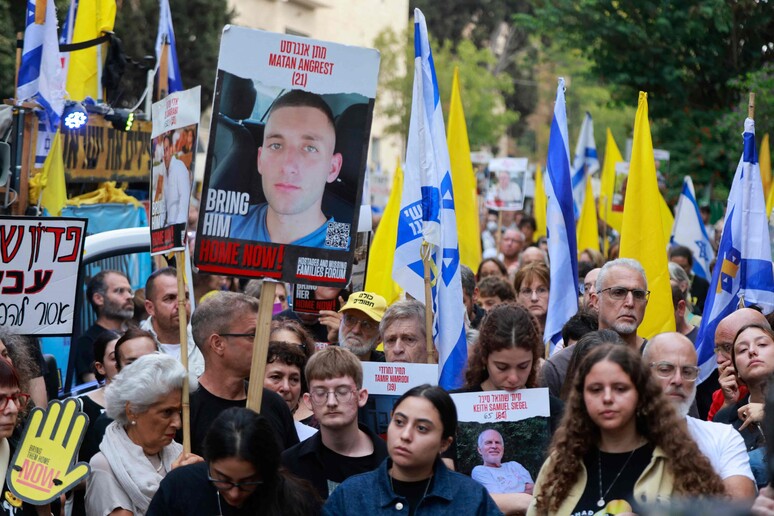 Cartaz com uma foto de Matan Angrest © ANSA/AFP