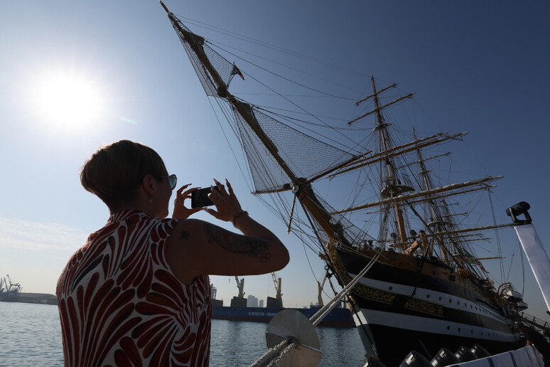 Uma visitante tirando uma foto do Amerigo Vespucci durante a parada em Abu Dhabi © ANSA/EPA