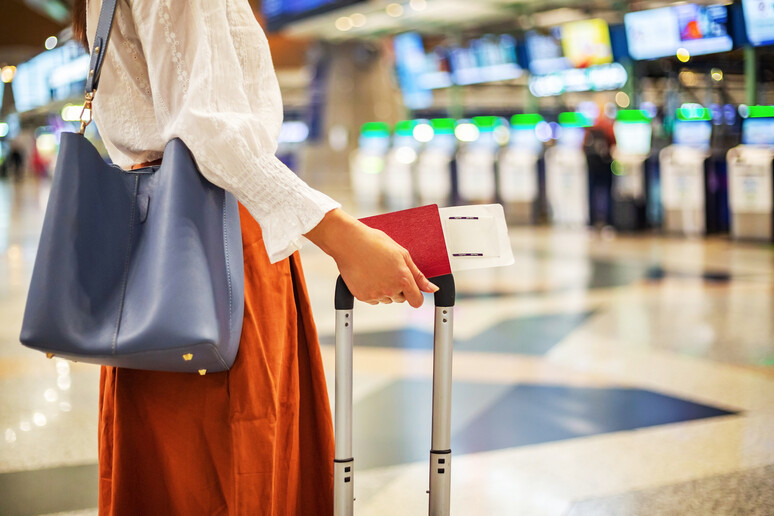 Una donna al gate di un aeroporto foto iStock. - RIPRODUZIONE RISERVATA