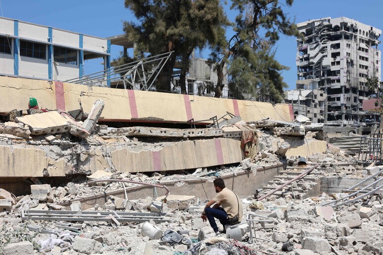 Homem diante de escola atingida por ataque israelense na Cidade de Gaza © ANSA/AFP