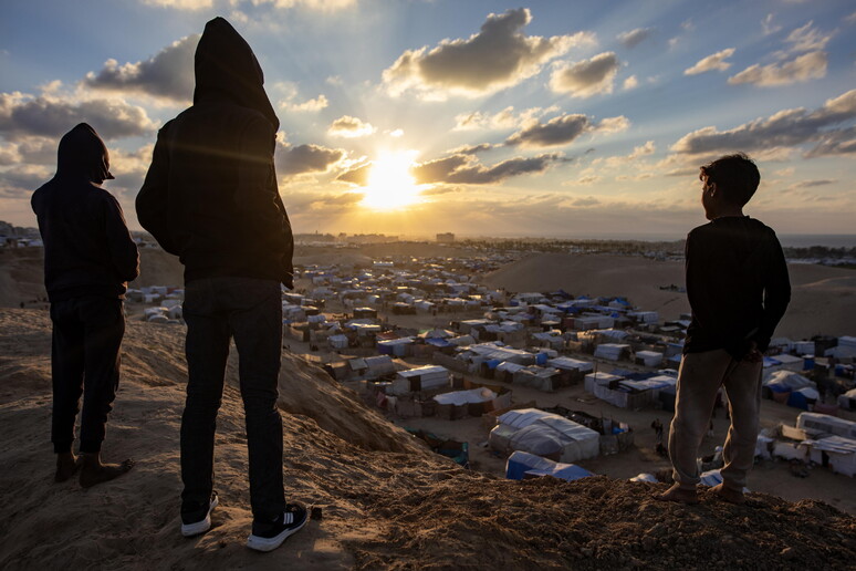 Palestinos assistem a pôr do Sol na véspera de cessar-fogo em Gaza © ANSA/EPA