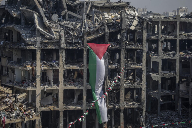 Bandeira palestina em prédio destruído por bombardeio israelense em Gaza © ANSA/EPA