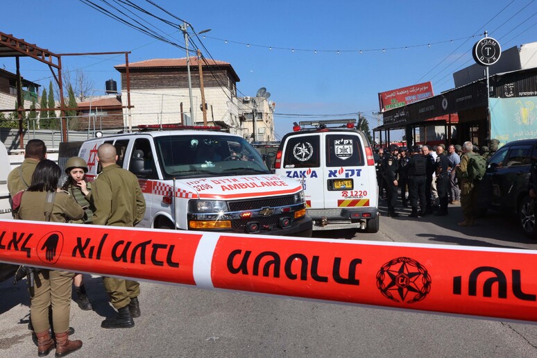 Paramédicos socorrem vítimas de ataque a tiros no vilarejo de Al Funduq © ANSA/AFP